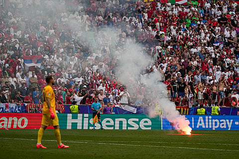 A flare burns on the pitch during the match between Slovenia and Serbia